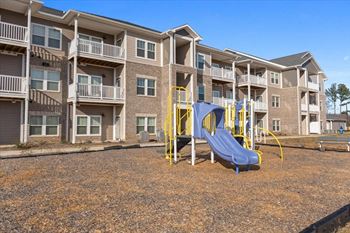a playground with a slide in front of Aurora apartments